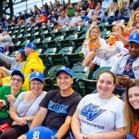 a large group of fans in gvsu night tigers hats sitting together and smiling for the camera